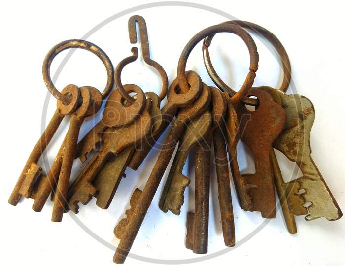 bunches of old rusty iron keys on a white background