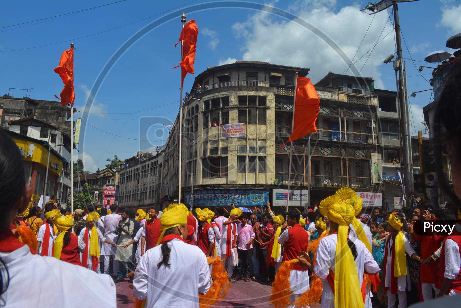 Pune, India - September 4, 2017: Dhol Tasha Pathak Dancing With Three Orange Flags Celebrating Ganapati Visarjan Festival. Dhol Tasha Pathak On Streets Of Pune With Orange Flags.