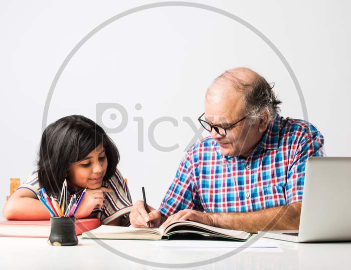 Indian Asian Grandfather Is Teaching His Granddaughter Or Grandaughter At Home
