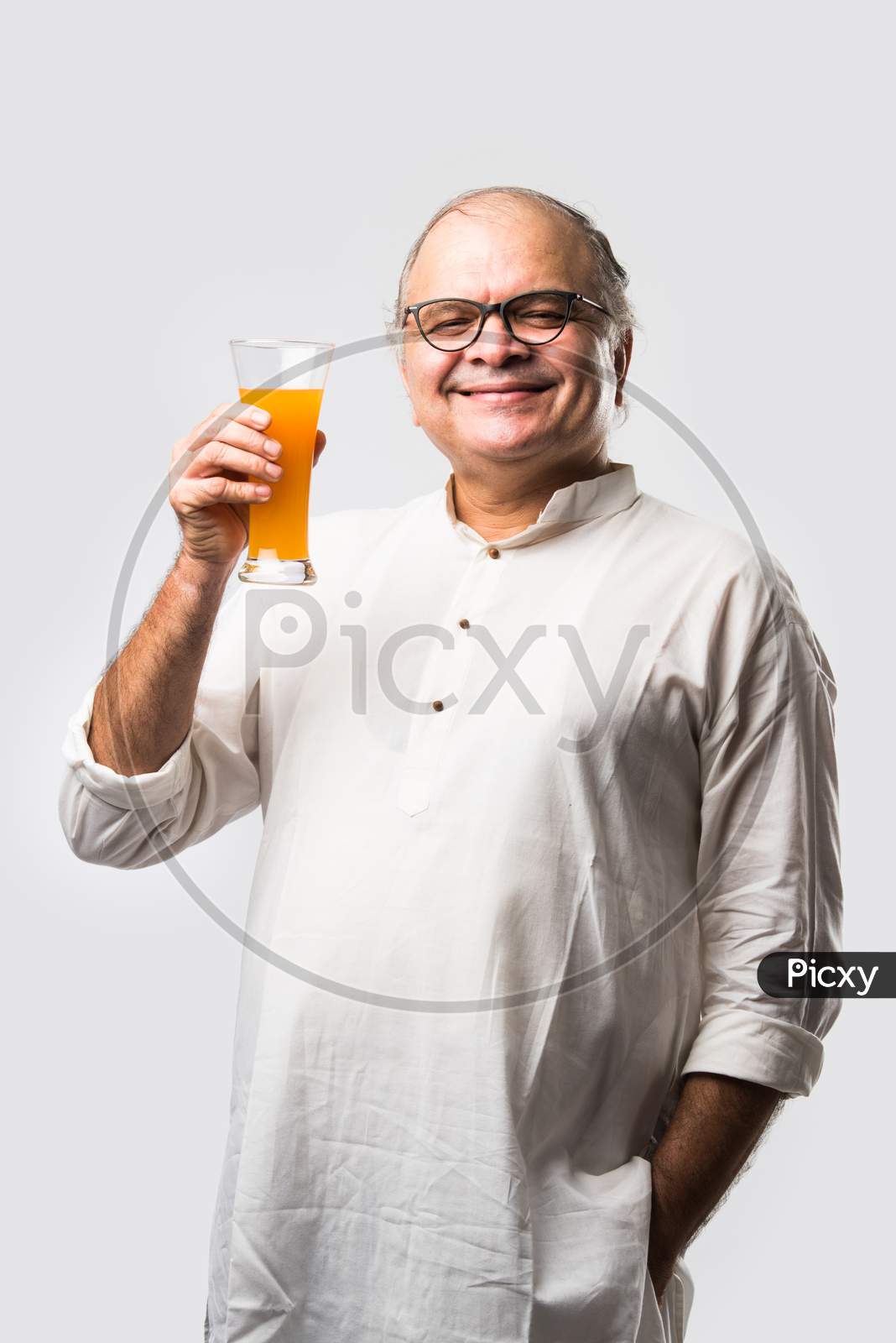 Indian Old Man  Holding Or Drinking Fresh Orange Or Mango Juice In Glass