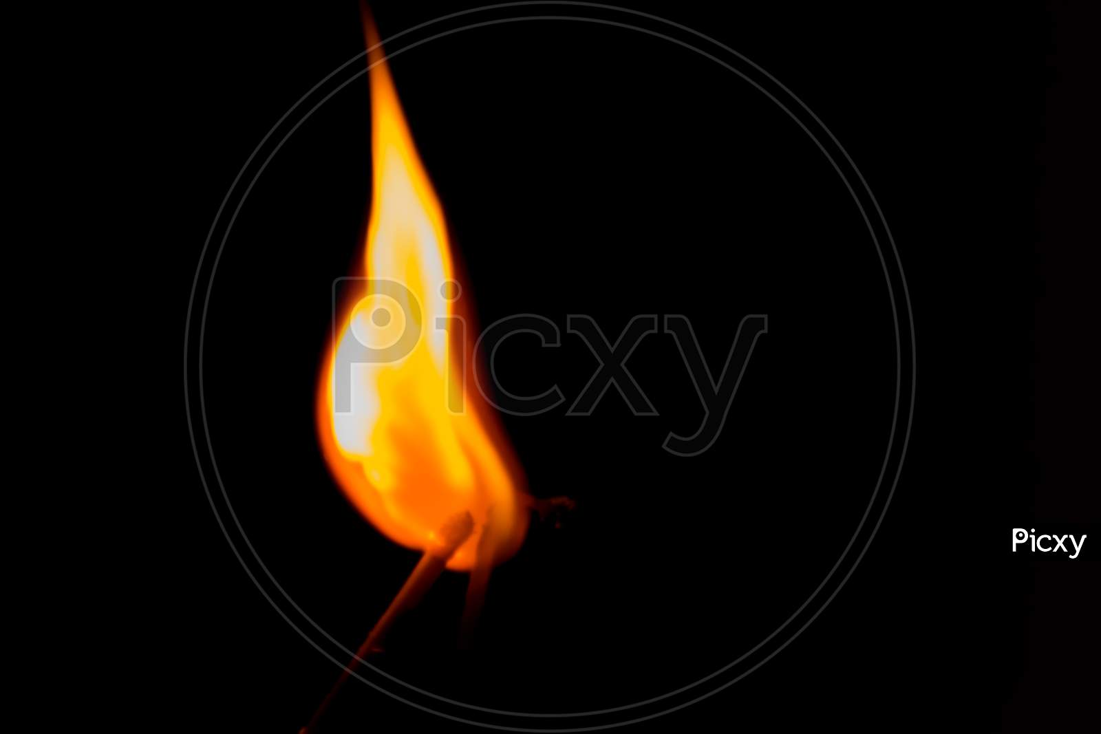 Close-Up Of A Burning Matchstick On A Black Background