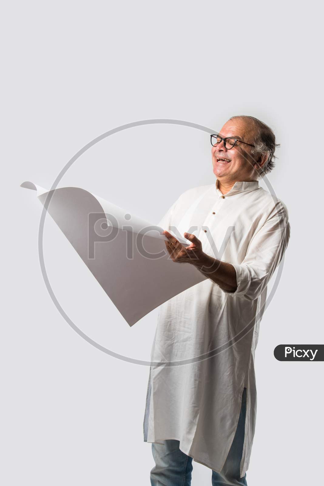 Indian Retired Senior Or Old Man Reading Book Or Newspaper