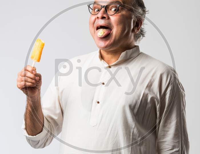 Retired Indian Old Man Eating Ice Cream, Standing Icolated Against White Background