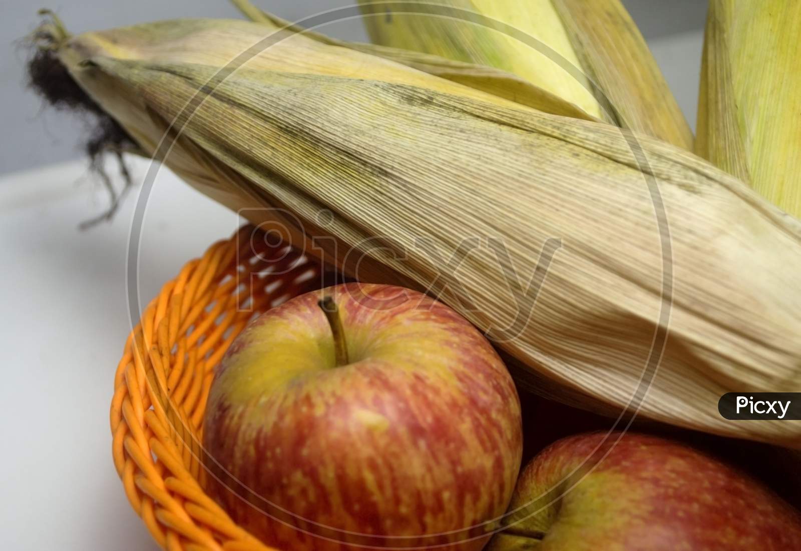 Apple And Leafed Corn On A Blurred Isolated Background