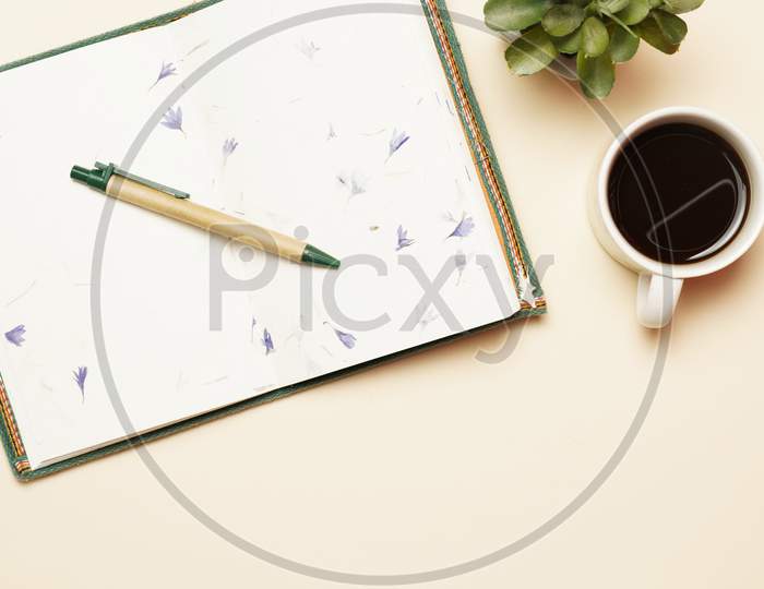 Top View Of Workspace With Coffee Open Notebook And Pen. Flat Lay
