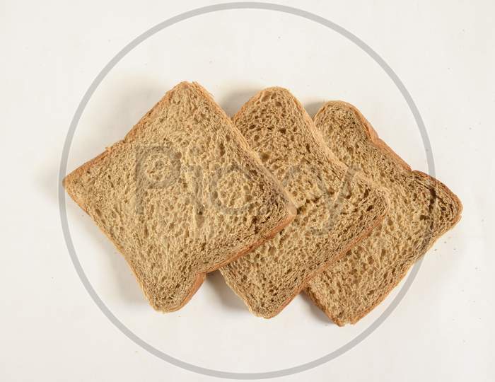 Sliced bread isolated on wooden background. Bread slices and crumbs viewed from above. Top view