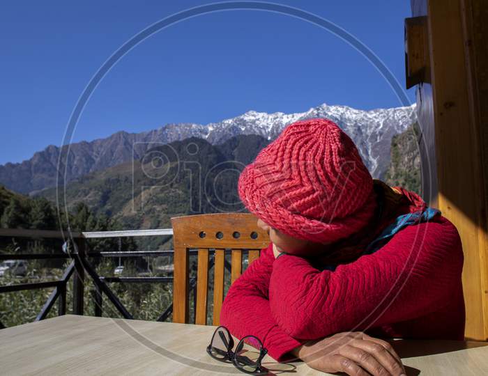 A Beautiful Young Lady With A Red Sweater Enjoying Nature On A Balcony Of A Restaurant On The Mountain Himalayas