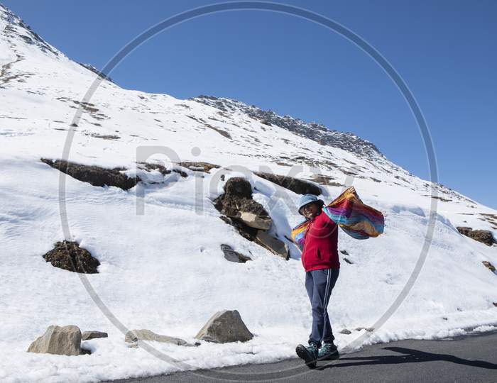 A Beautiful Young Lady With A Red Sweater And Sunglass Enjoying Nature On A Snow Covered High Altitude Pass On Himalaya