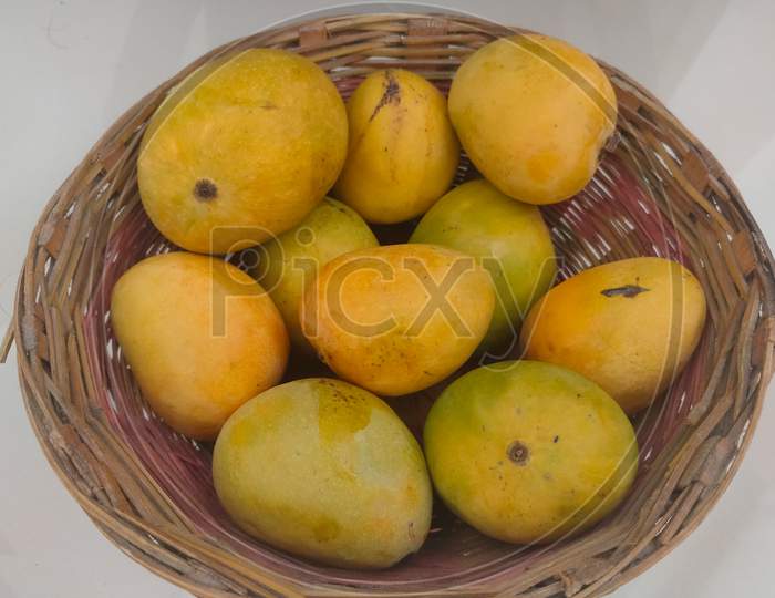 Mango Fruit In Wooden Basket Putting On Ceramic Floor Tile Background.