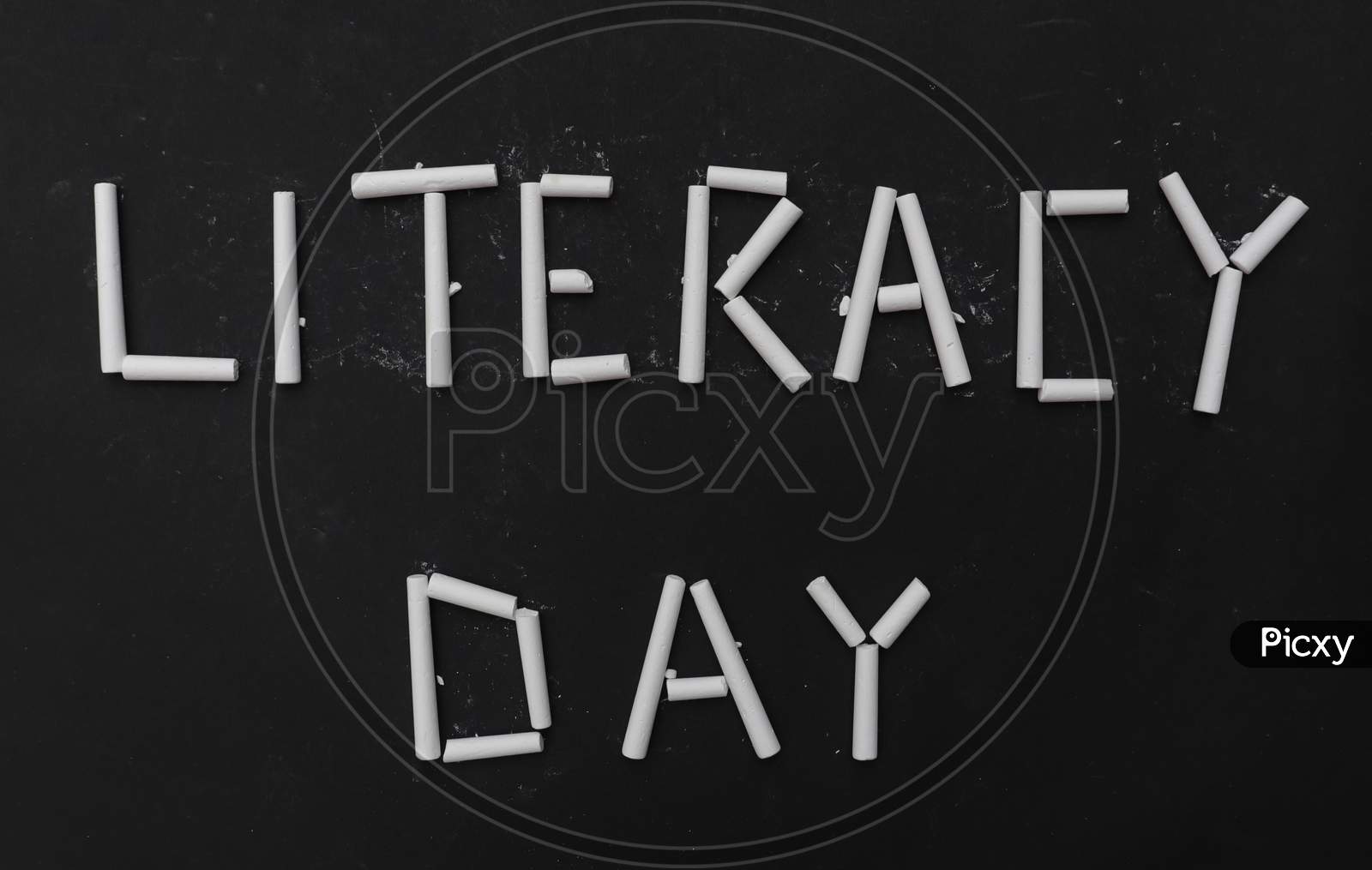Literacy Day Written With White Chalk Pieces On Black Background