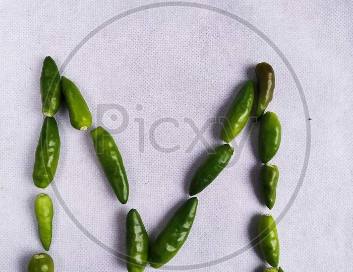 Green Chilli In  "M" Shape In A White Background