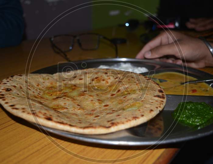 Parantha Plate On The Table With Daal And Chutney