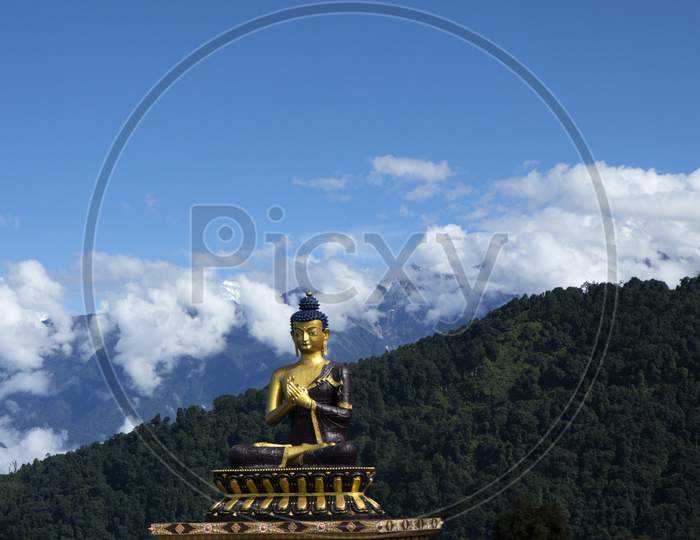 A Huge Statue Of Lord Buddha In A Sunny Morning In Buddha Park With The Kanchenjunga Snow Peak In Background In Sikkim In India