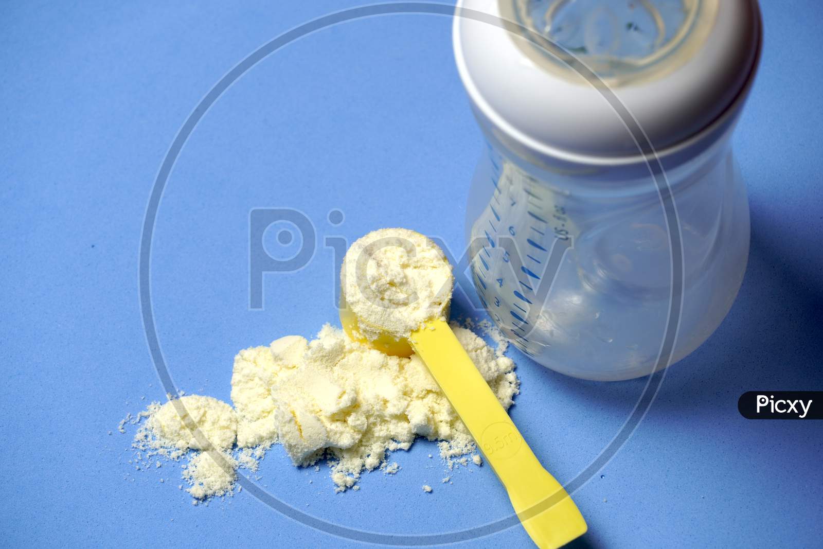 Top View Of Baby Powder Milk With Scoop Next To A Baby Bottle. Formula Milk