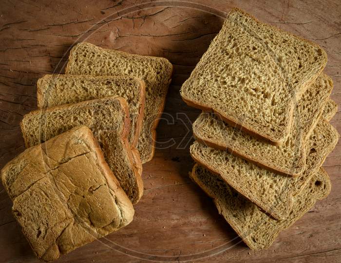 Sliced bread isolated on wooden background. Bread slices and crumbs viewed from above. Top view