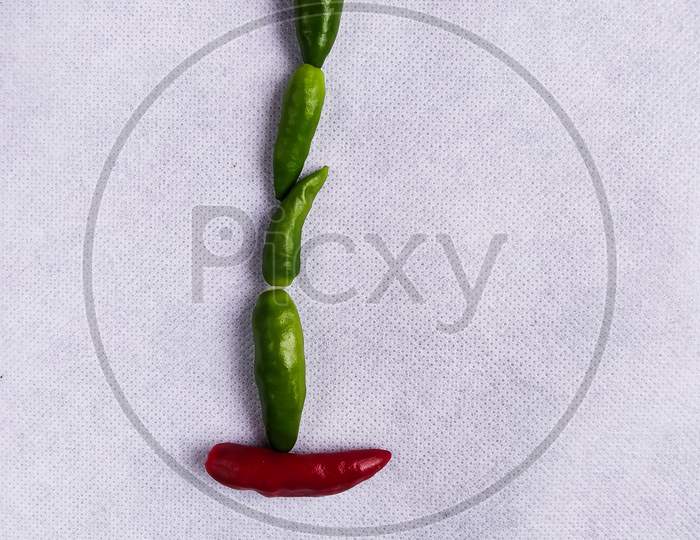 Red And Green Chilli In "I" Shape In A White Background