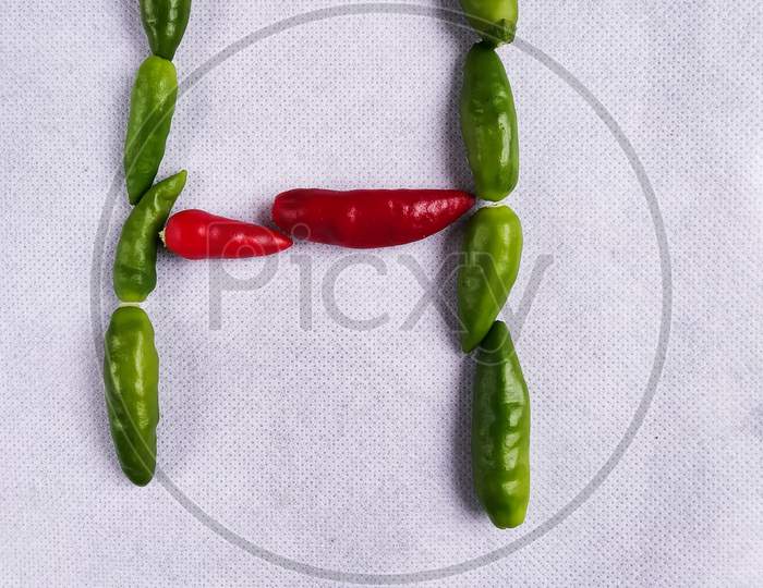 Red And Green Chilli In "H" Shape In A White Background