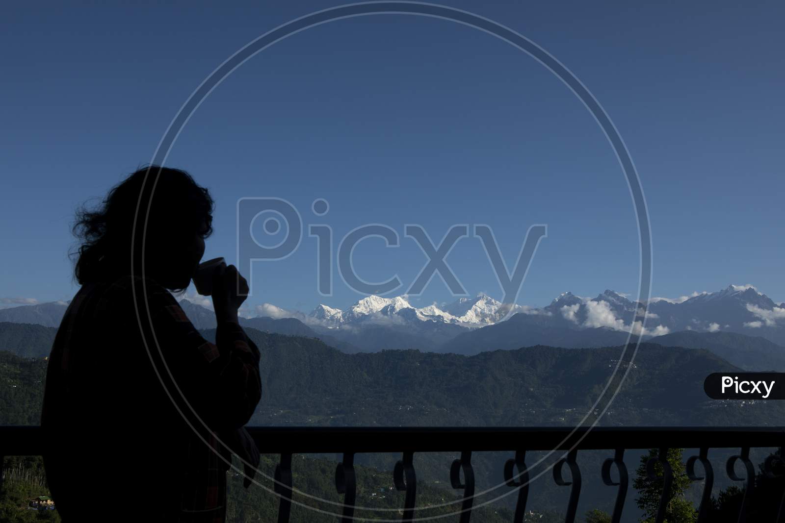 The Mighty Kanchanjunga With Other Snow Peaks At The Background Of A Small Village On The Slope Of Mountains On The Himalaya From The Balcony Of A Tourist Cottage With Morning Tea In Sikkim