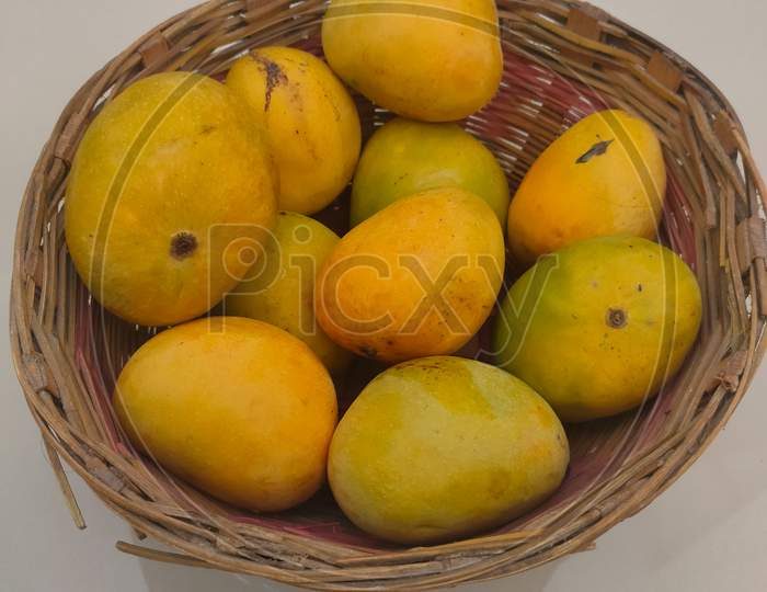 Mango Fruit In Wooden Basket Putting On Ceramic Floor Tile Background.