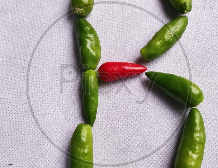 Red And Green Chilli In "B" Shape In A White Background