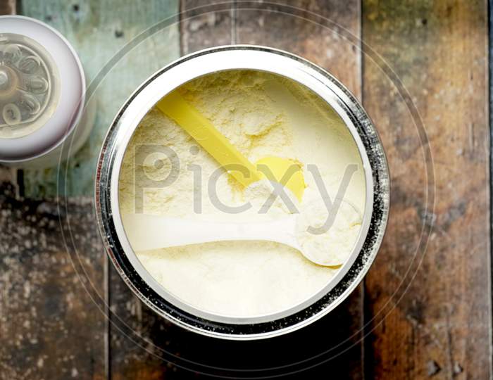 Top View Of Baby Powder Milk With Scoop Next To A Baby Bottle. Flat Lay Flat Design