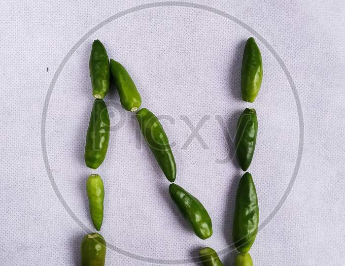 Green Chilli In A "N" Shape In A White Background