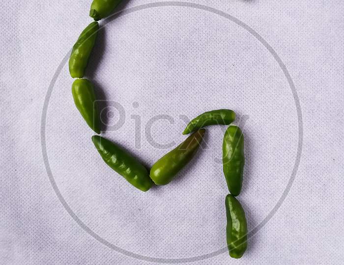 Green Chilli In "G" Shape In A White Background