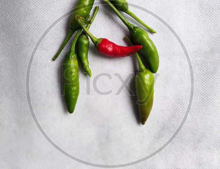 Green Chilli In "A" Shape In A White Background