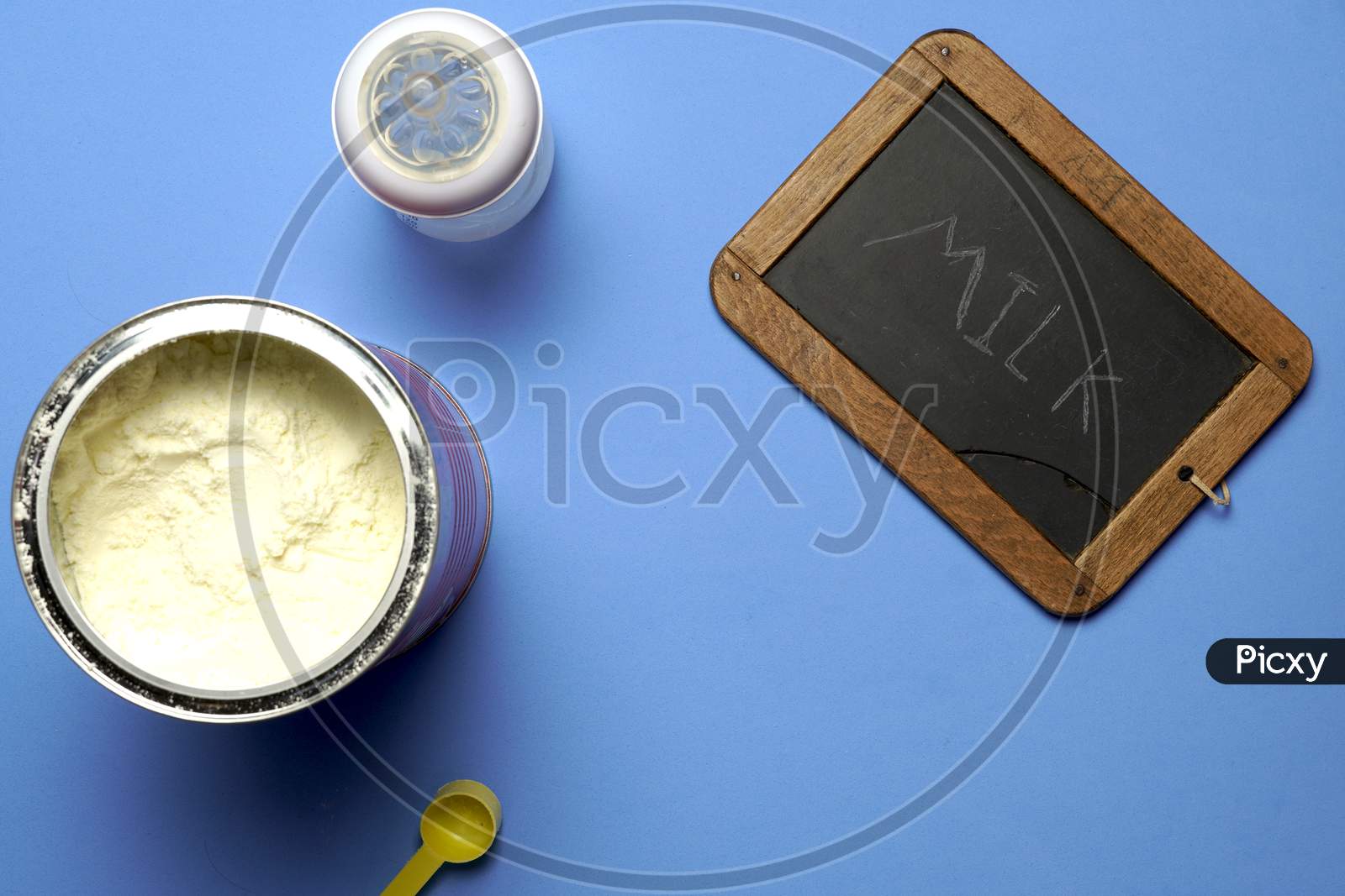 Top View Of Powdered Milk Next To A Blackboard With The Word Milk Written In Chalk- Flat Lay Flat Design