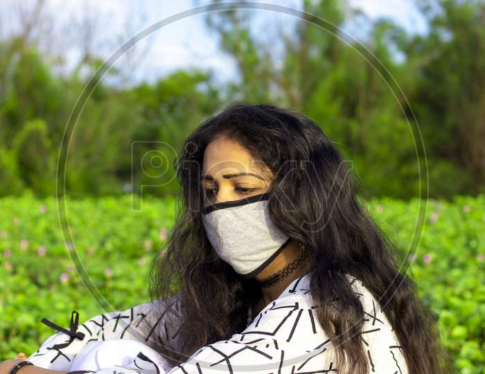 Portrait Of A Stylish Young Girl Sitting In The Nature