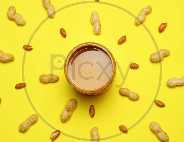 Top View Of Peanut Butter With Peanuts In The Background. Flat Lay