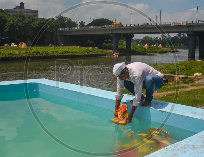 Pune, India - September 4, 2017: Pune Ganpati Visarjan In Small Water Tanks To Save Water Pollution. A Person Is Doing Ganpati Visarjan In A Water Tank To Save Water Pollution.