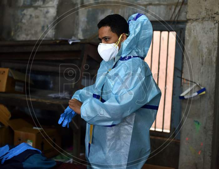 An Indian Health worker wears a Personal Protective Equipment (PPE) before taking swab samples of people suspected for coronavirus COVID-19 in Nagaon District of Assam on Sep 08,2020