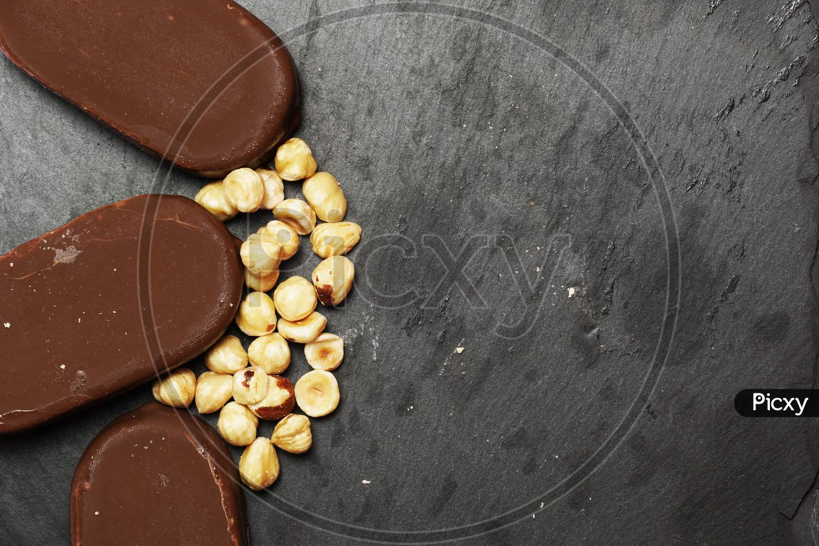 Top View Of Chocolate Ice Cream On Slate Plate With Hazelnuts. Flat Lay