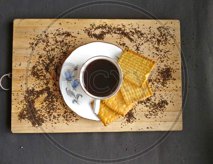 Red tea with biscuits kept on wooden board