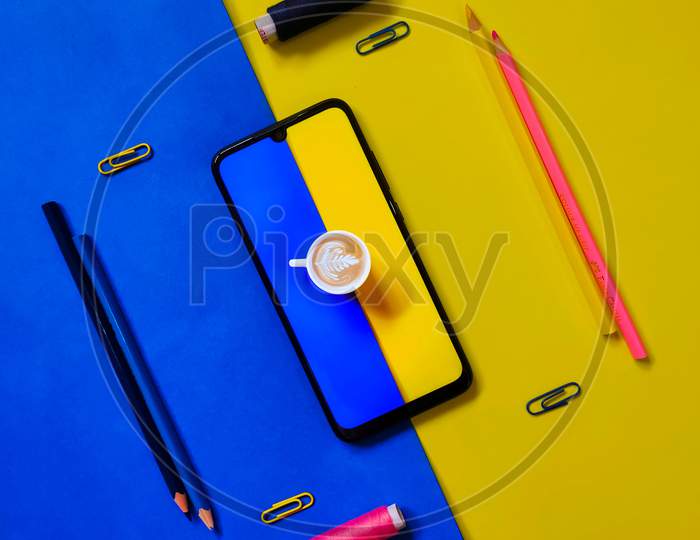 Coffee cup inside a smartphone with coloured objects