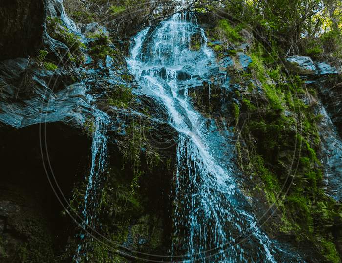 Shot From Below A Massive Waterfall In The Middle Of The Nature In A Forest During A Rainy Day