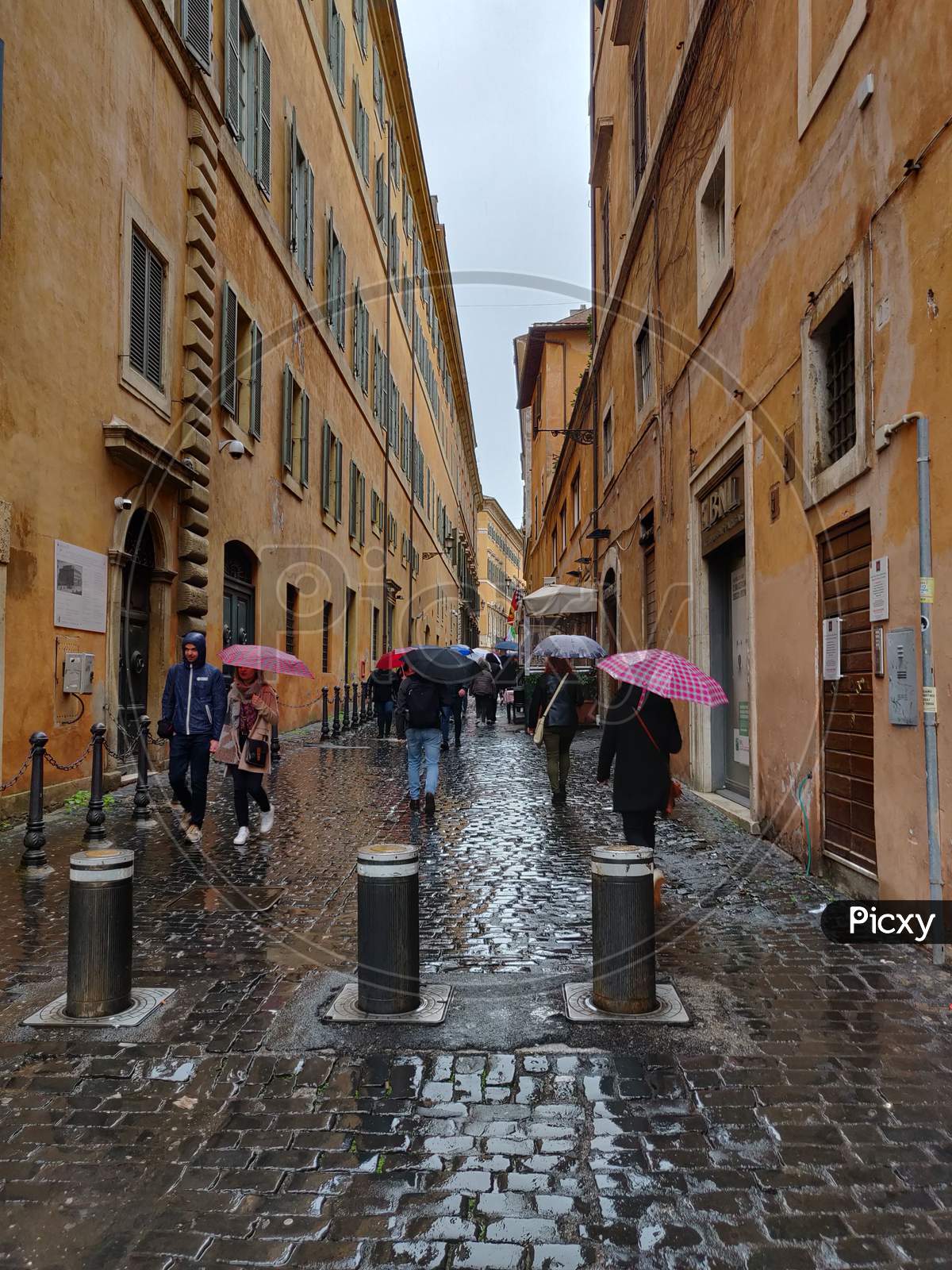 People walking in the rain in Via dei Giustiniani
