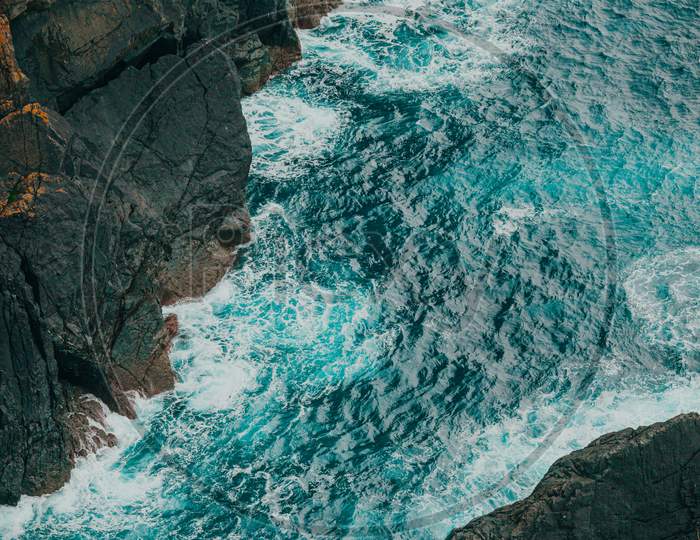 Close Up Of The Ocean Between Two Giant Rocks With Copy Space