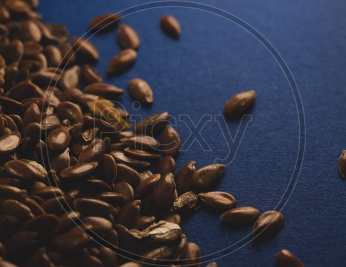 Raw Flax Linseed On Blue Background