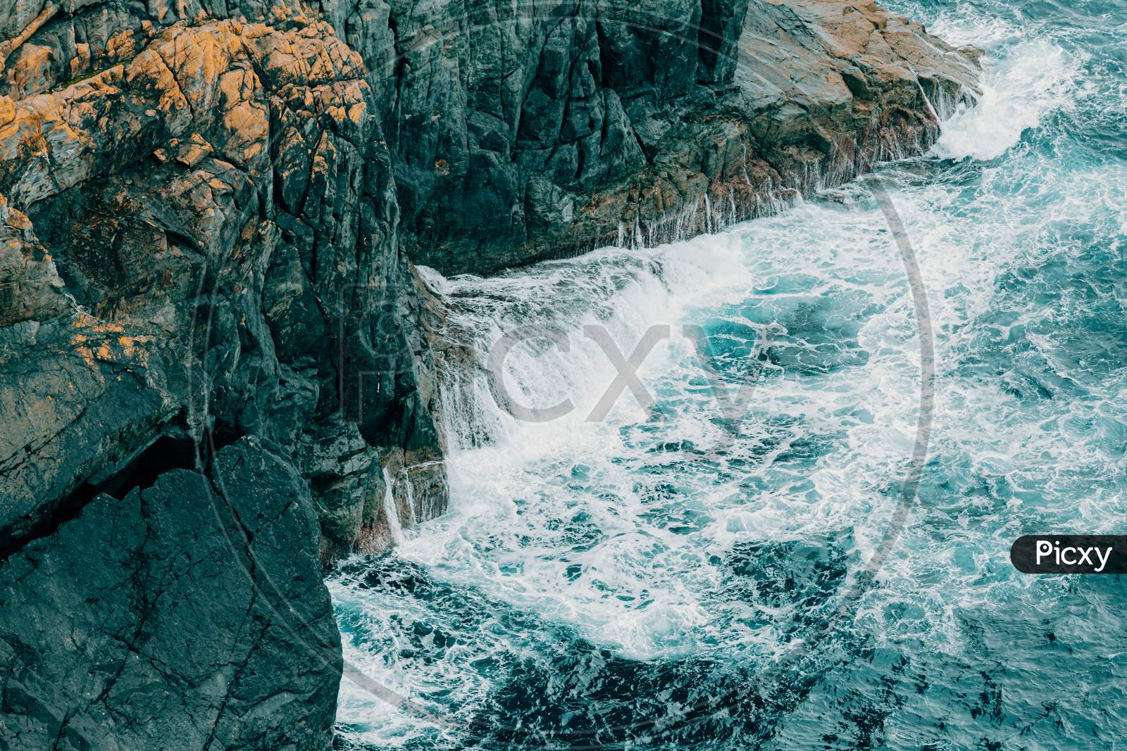 Close Up Of The Water Crashing Against A Giant Rock In The Middle Of The Ocean