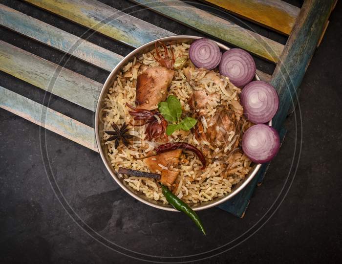 Delicious chicken biryani top view.Biryani rice dish Beautiful Indian rice dish.Delicious spicy chicken biryani in bowl over moody background, it’s a popular Indian and Pakistani food.