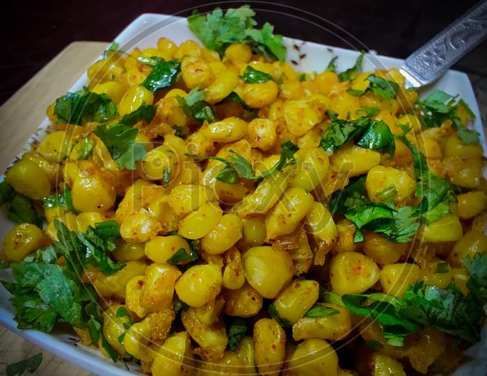 Testy fried corn garnish with chopped coriander leaves and some spices