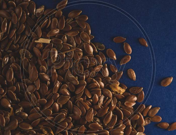 Raw Flax Linseed On Blue Background