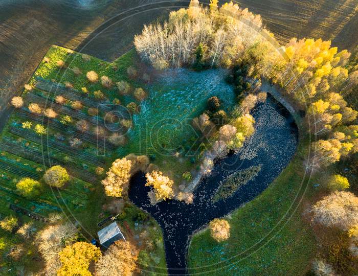 Drone Photography Of A Pond Behind The House Surrounded With Beautiful Autumn Colors