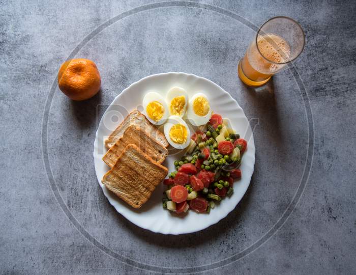 Top view of healthy food items bread slices, boiled vegetables and eggs