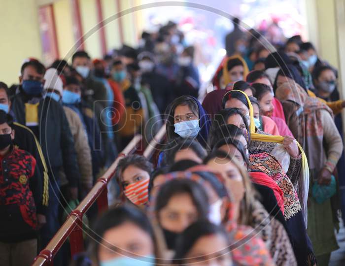 People stand in a queue , not adhering to social distancing norms, to pay obeisance at Kali Mata Temple on the first day of New Year 2021, in Jammu ,1 January,2021.