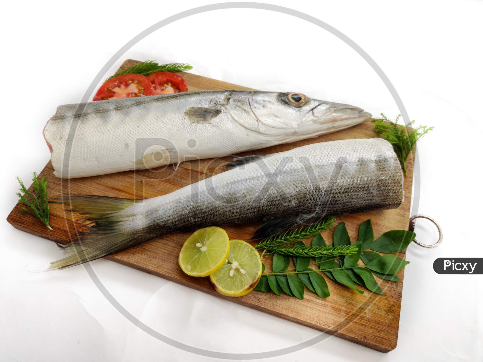 Fresh Raw Barracuda Fish (Cheelavu) Head And Body Decorated With Herbs And Vegetables On A White Background.Selective Focus.
