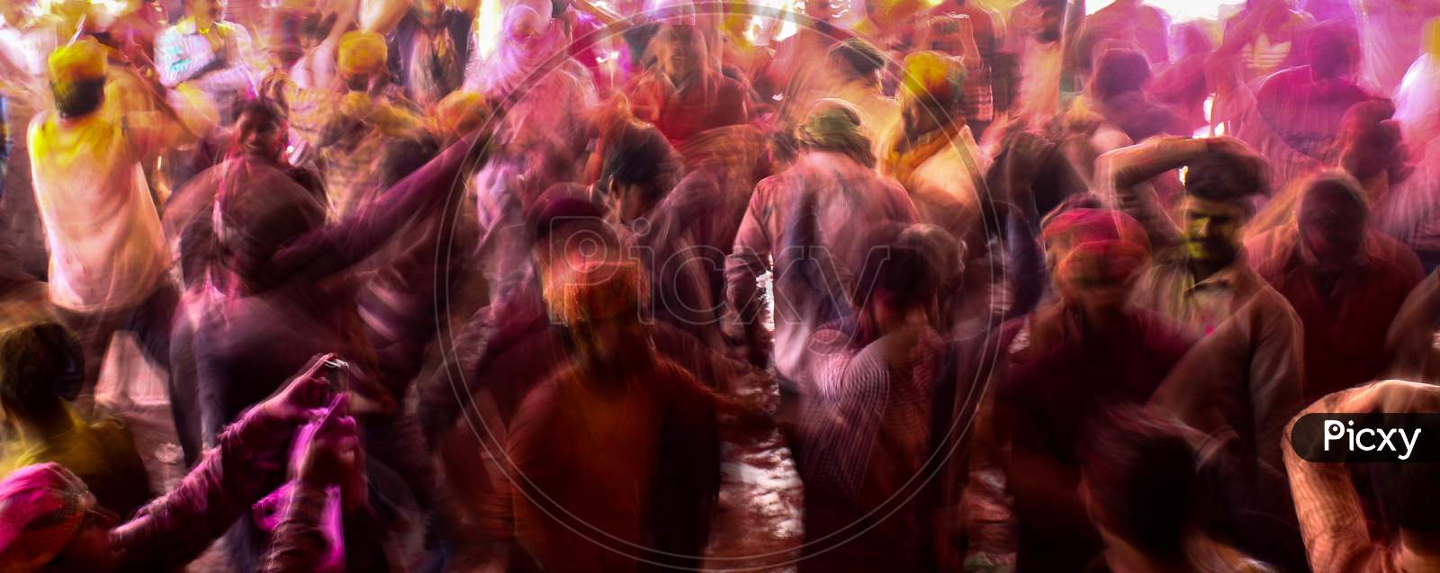 Mathura, Uttar Pradesh/ India- January 6 2020: A Crowd Of People Raising Their Hands Up And Enjoying Music On The Street Of Mathura Celebrating Holi Festival With Color Powder Captured In Slow Shutter Speed.