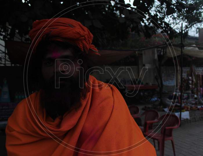 Mathura, Uttar Pradesh/ India- January 6 2020: Portait Of Sadhu Baba (Monk) With Beard Wearing Orange Get-Up Participating Holi Festival With Colorful Faces At Mathura.